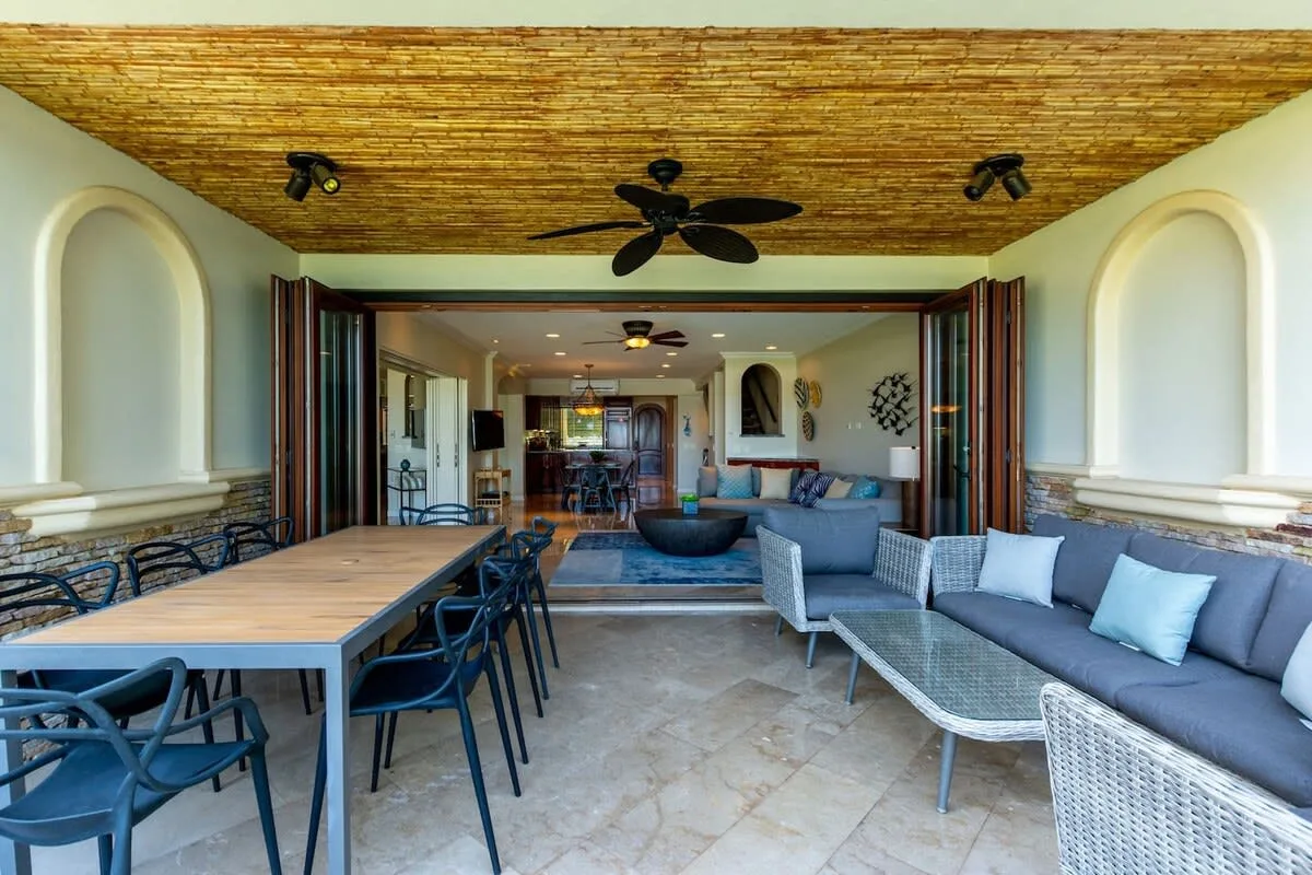 A covered patio with dining seating and a lounge area.