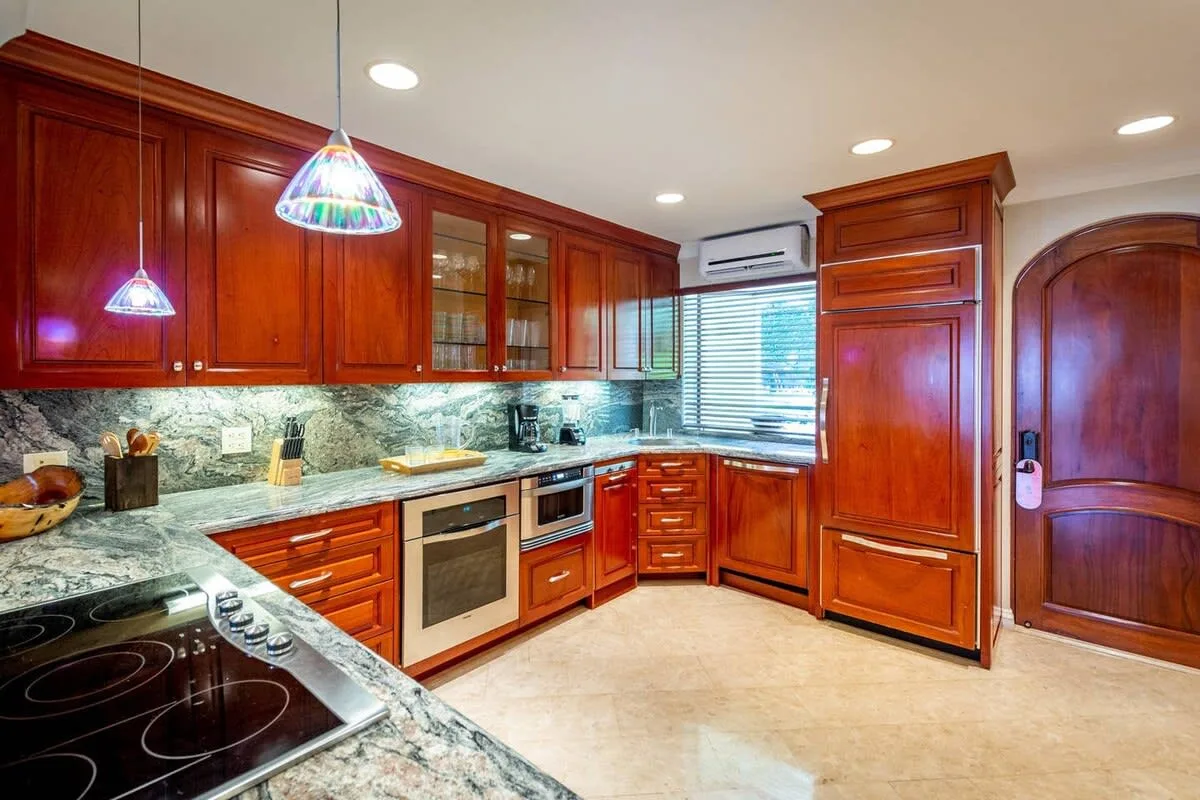 A kitchen with wooden cabinets, a countertop, and a built-in cooktop.