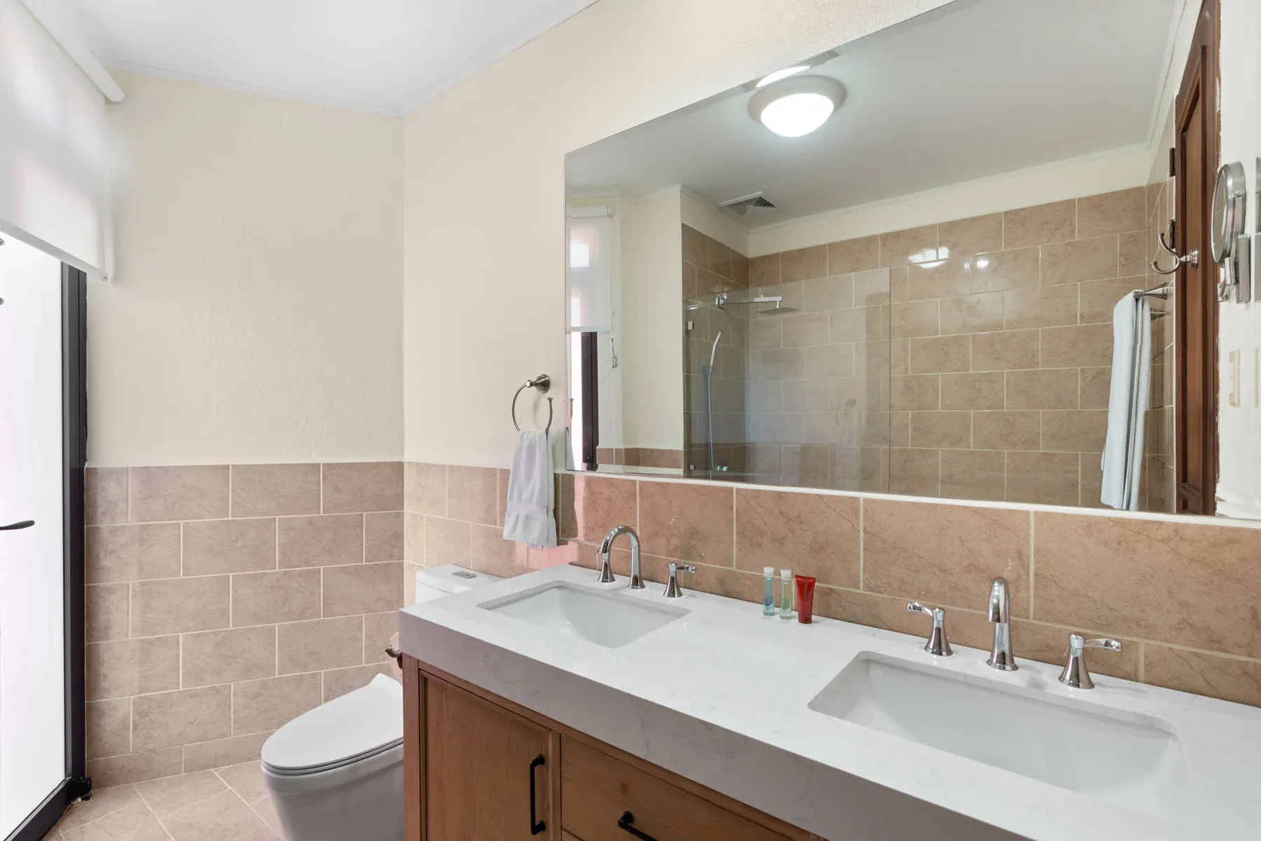 A bathroom vanity with two sinks and a large mirror.