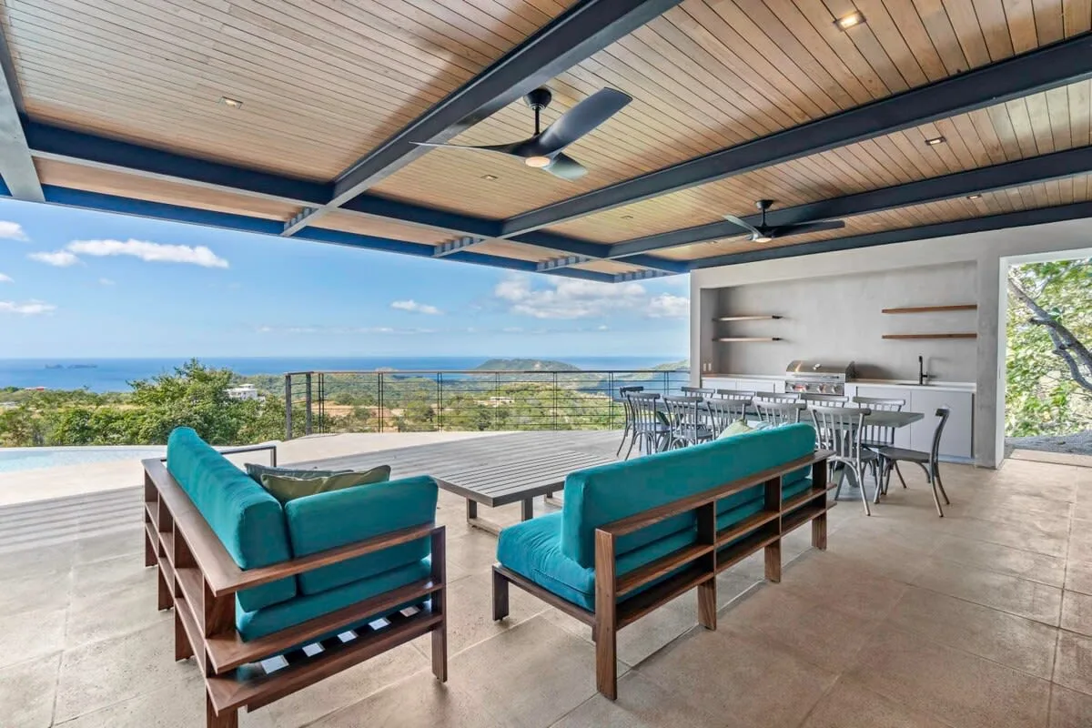 A covered outdoor dining and lounge area overlooks the ocean.