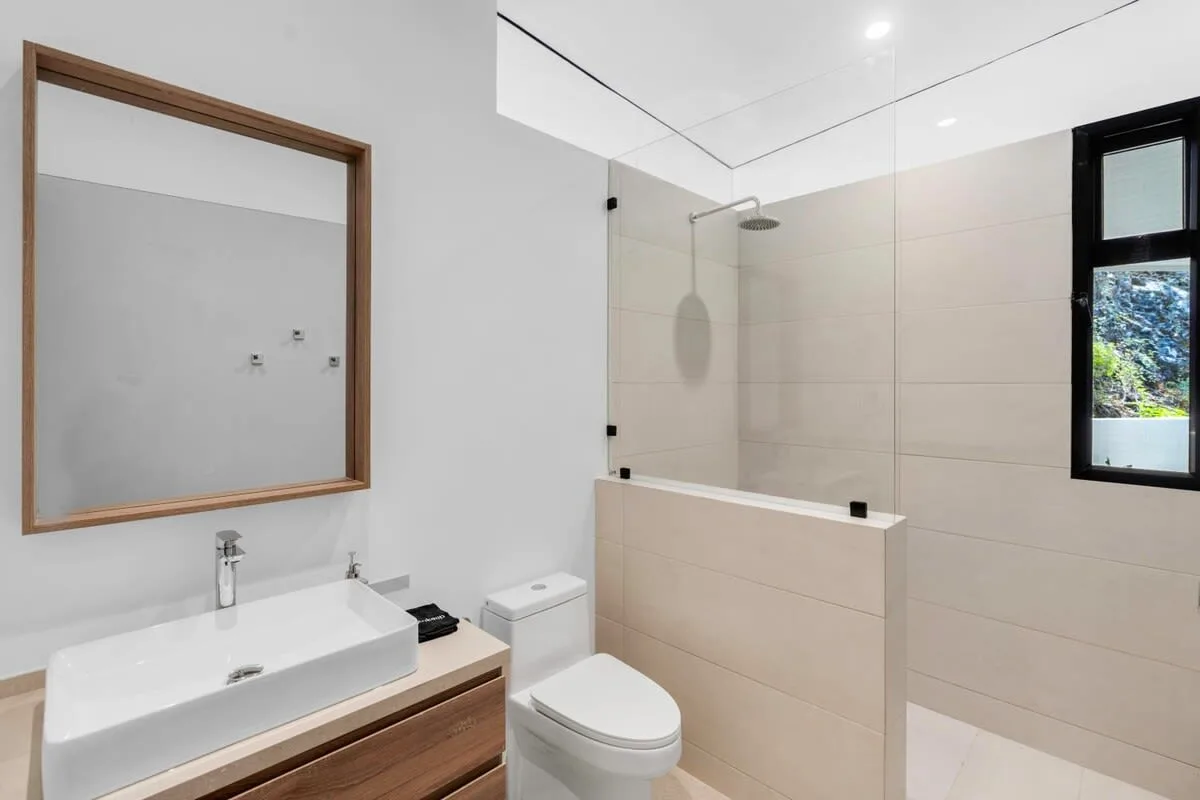 A modern bathroom with a sink, toilet, and glass shower.