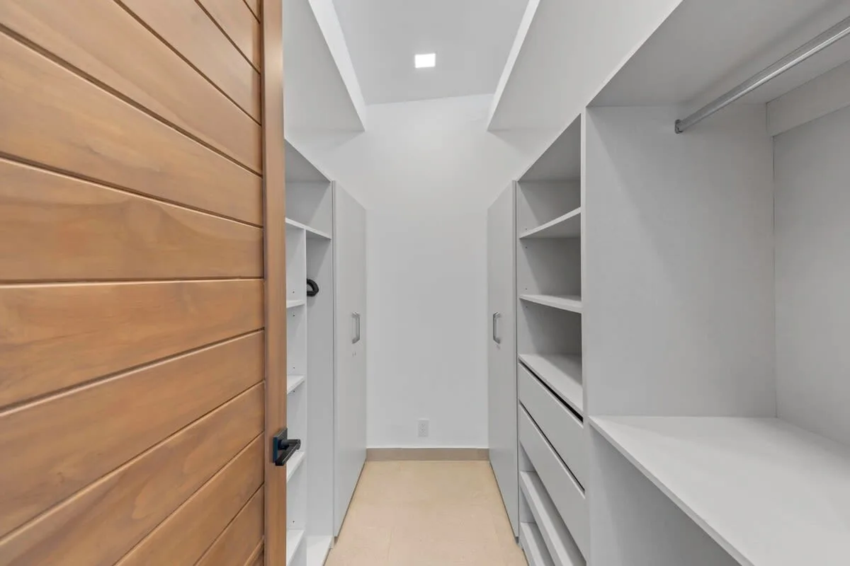 A walk-in closet with built-in shelving and a countertop.
