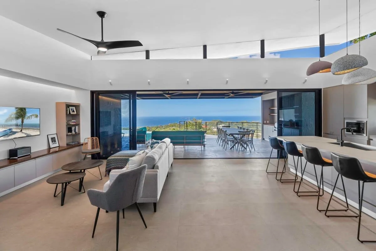 A bright open-plan living and dining area opens onto a terrace with sea views.