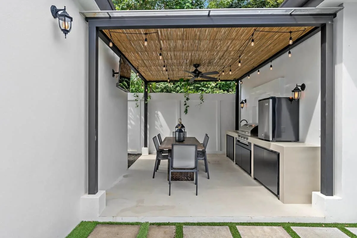 A covered outdoor dining area with a table and built-in counter.