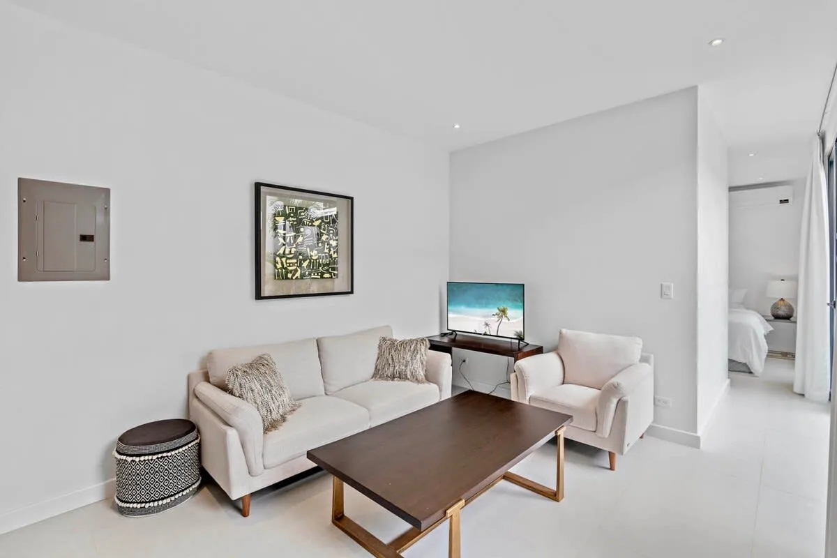 A bright living room with a sofa, armchair, and low coffee table.