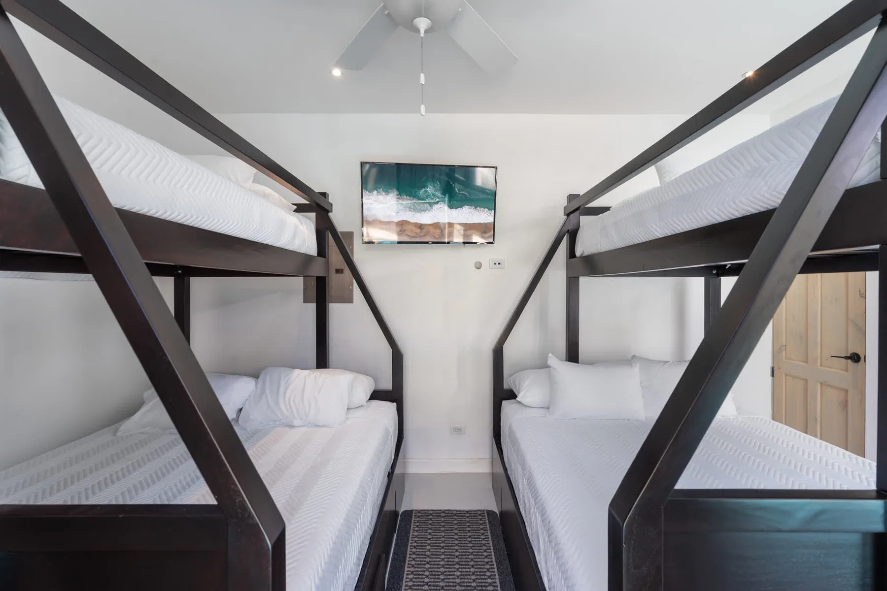A bedroom with two bunk beds and a framed picture on the wall.