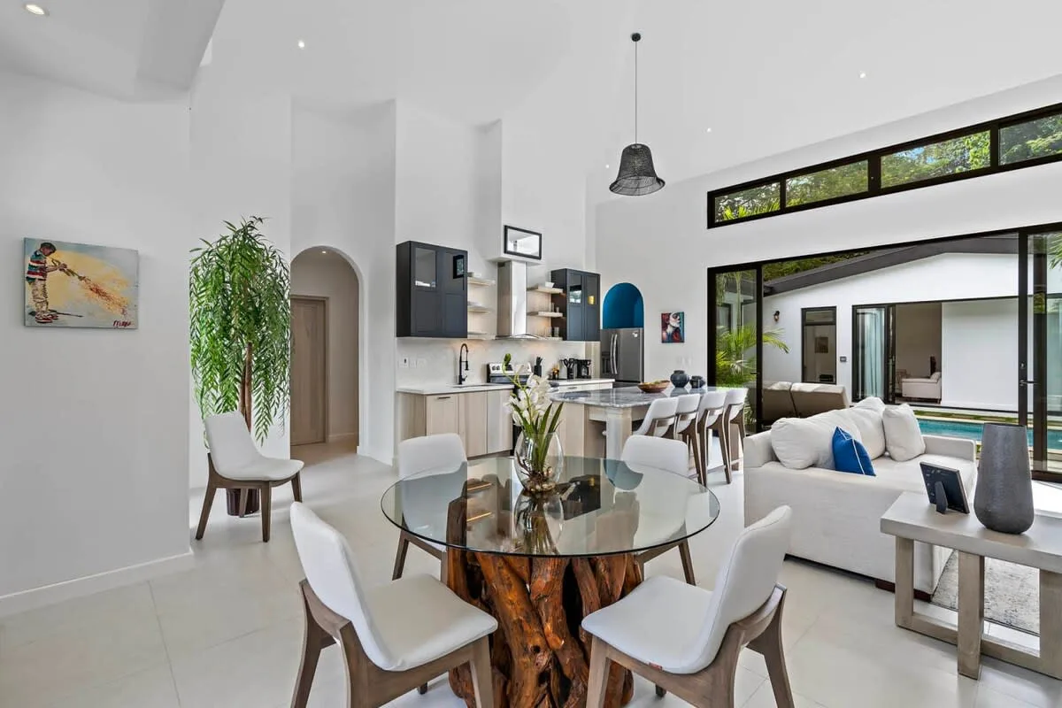 An open-plan living and dining area with a kitchen and large windows.
