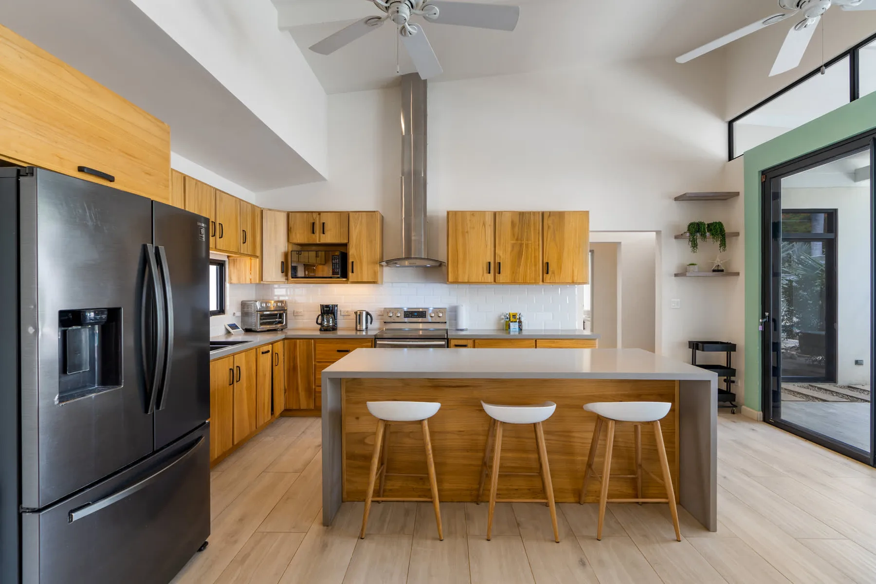 A bright kitchen with wooden cabinets, stainless steel appliances, and a central island.