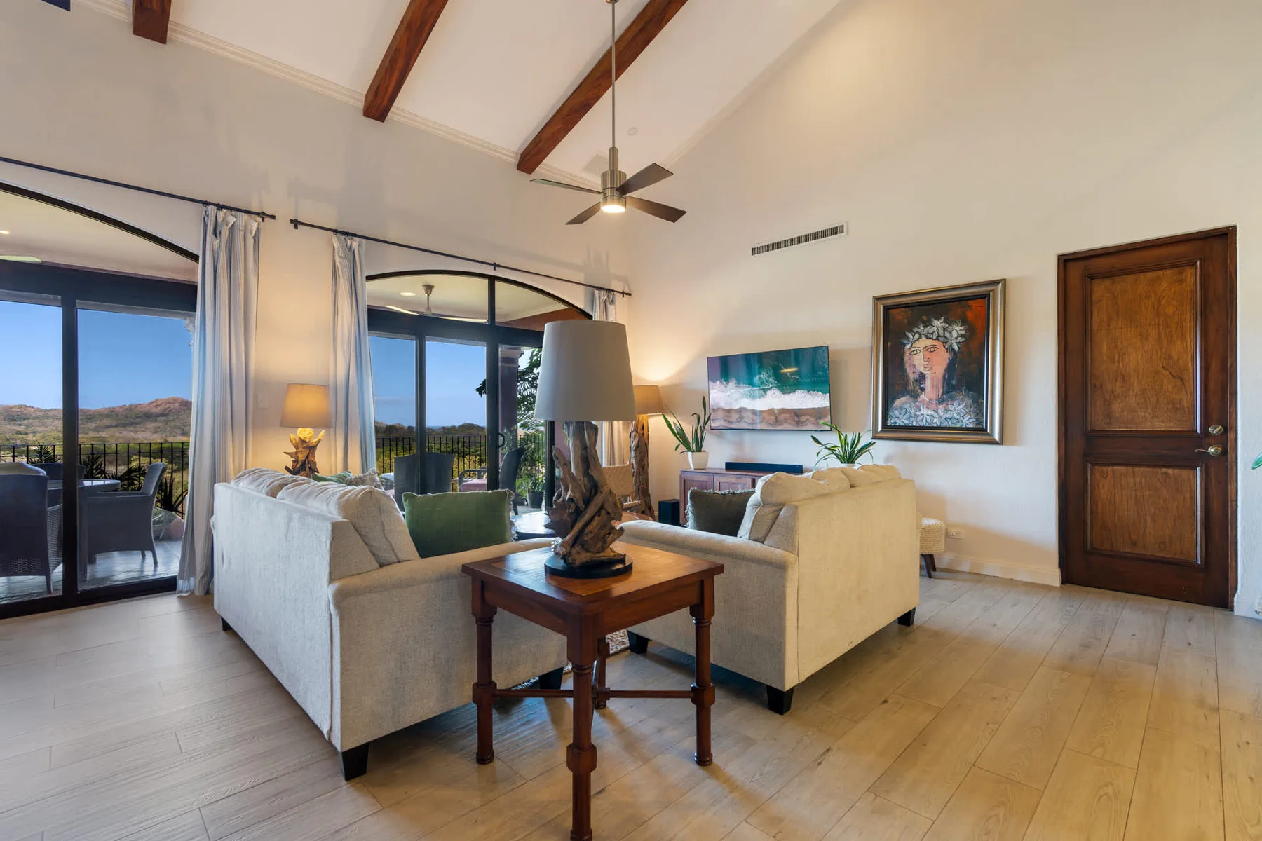A bright living room with seating, a coffee table, and large glass doors.
