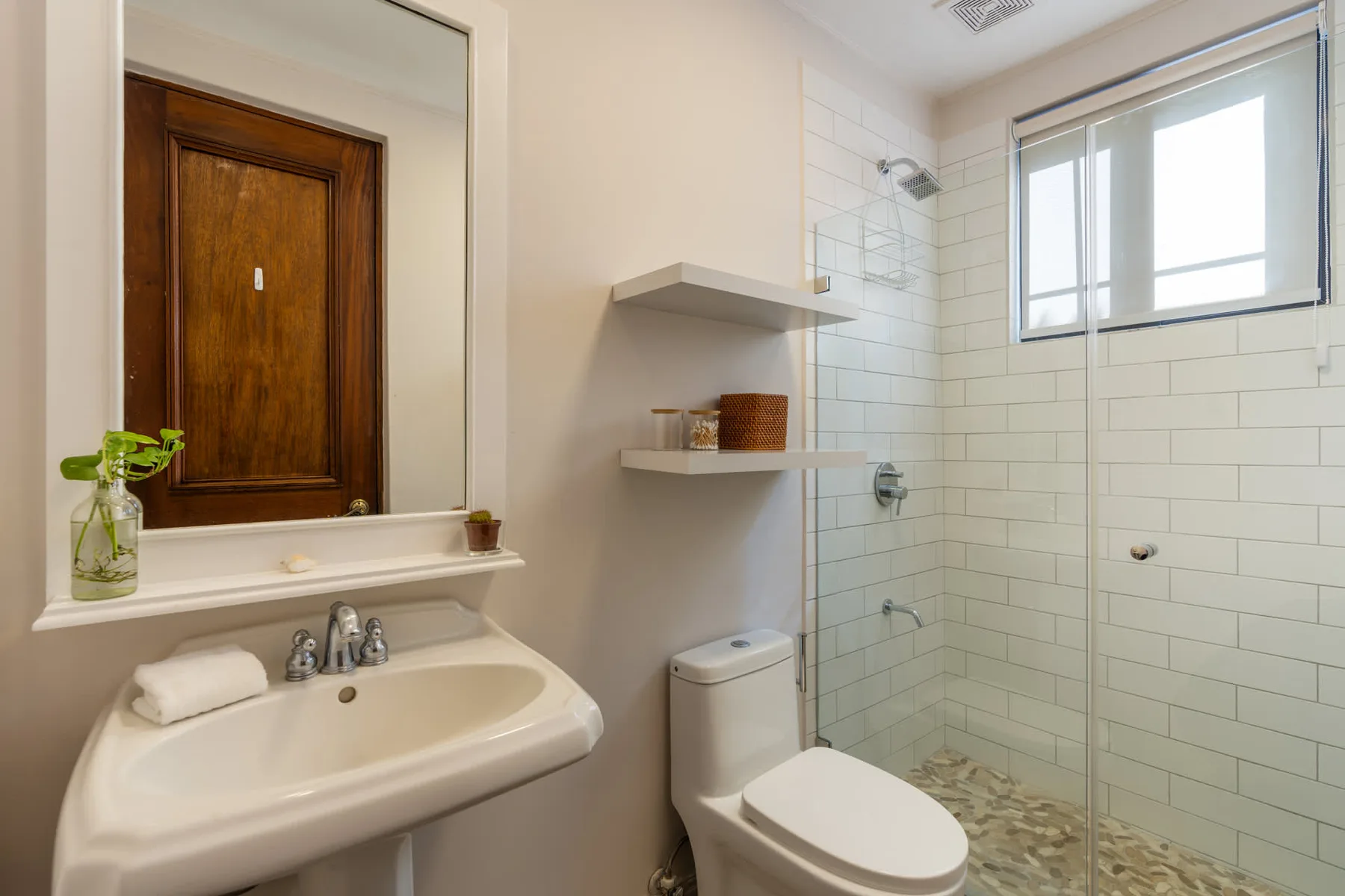 Un baño con lavabo, inodoro y zona de ducha con azulejos.