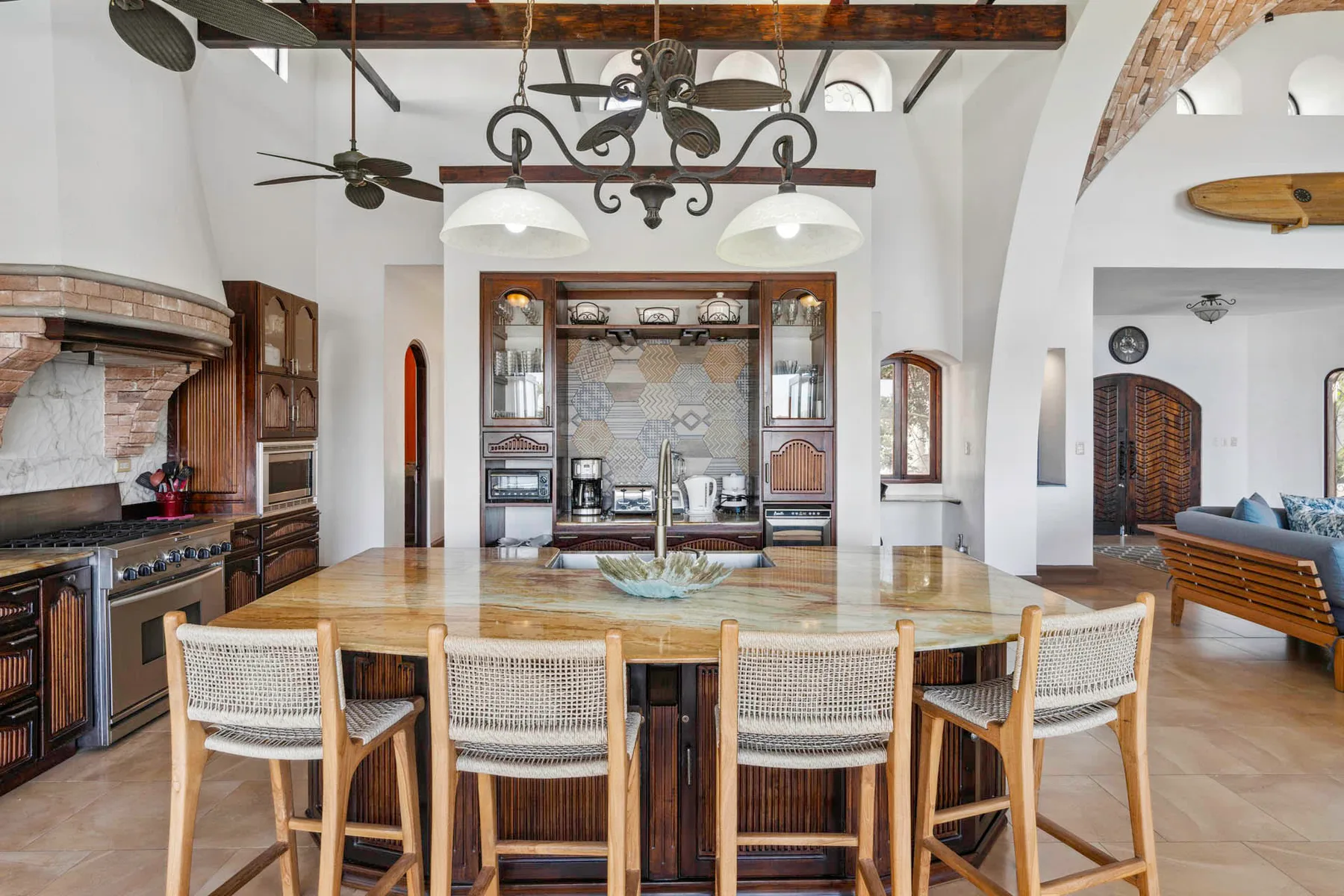 A spacious kitchen and dining area with a large wooden table and woven seating.