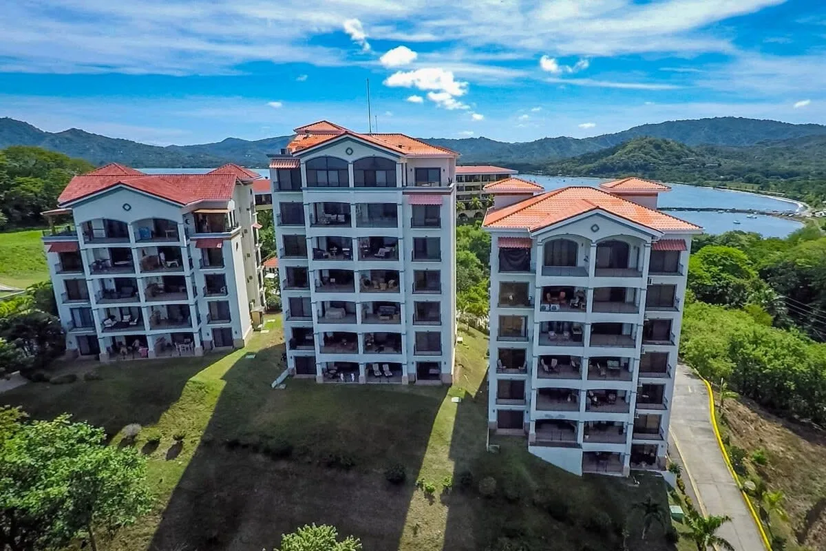 Shared amenity: Apartment buildings stand beside a green landscape with hills and water in the distance.