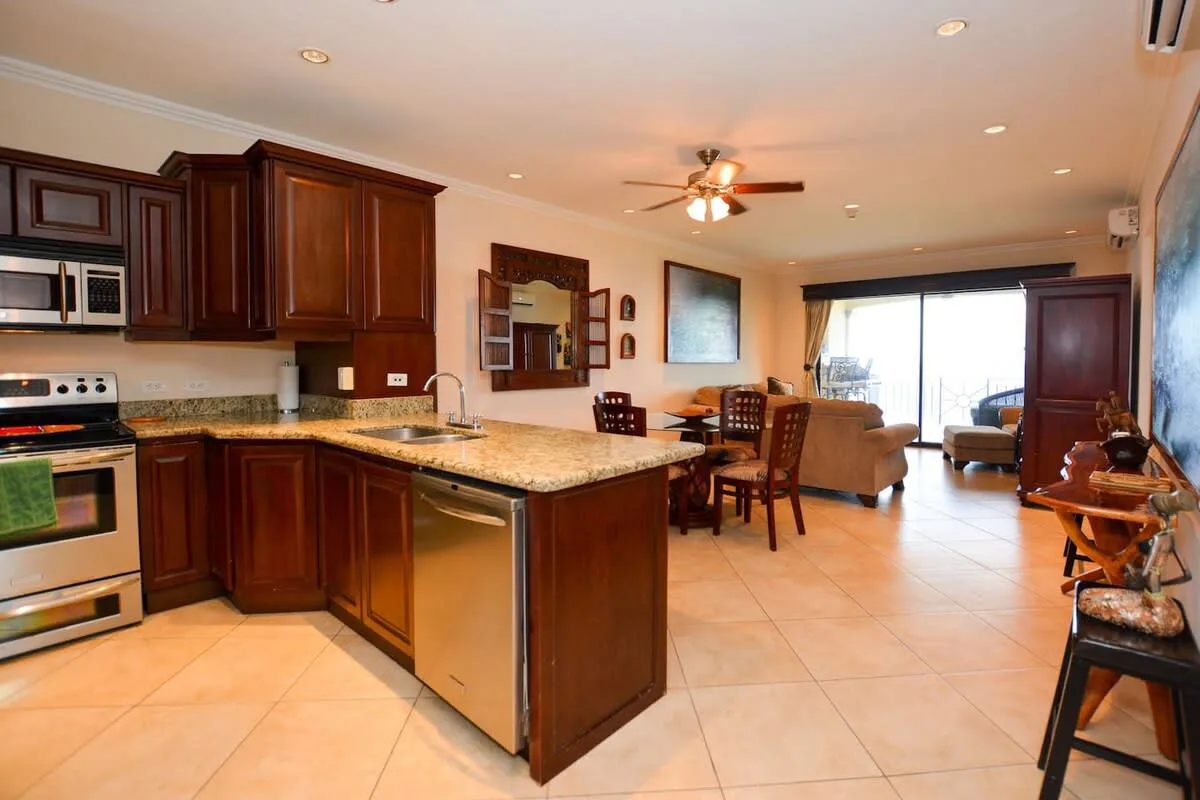 An open-plan kitchen and dining area with dark wood cabinets and a dining table.