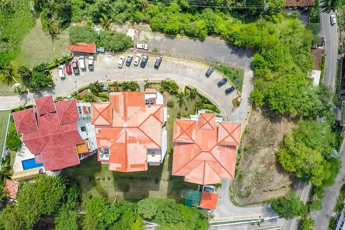 Shared amenity: Aerial view of several red-roofed buildings beside a curved parking area.