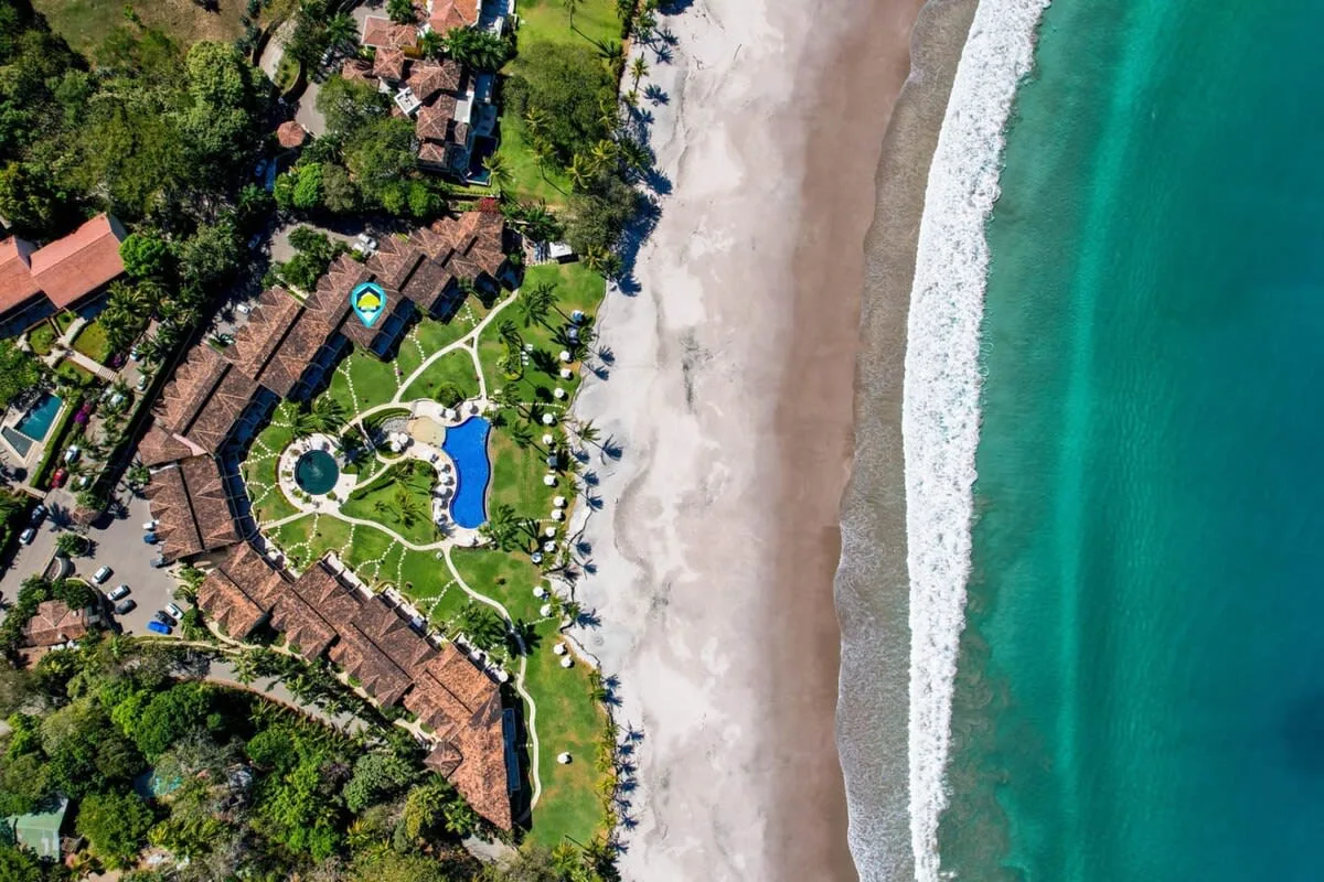 Zona común: Vista aérea de un complejo turístico junto a una amplia playa de arena.