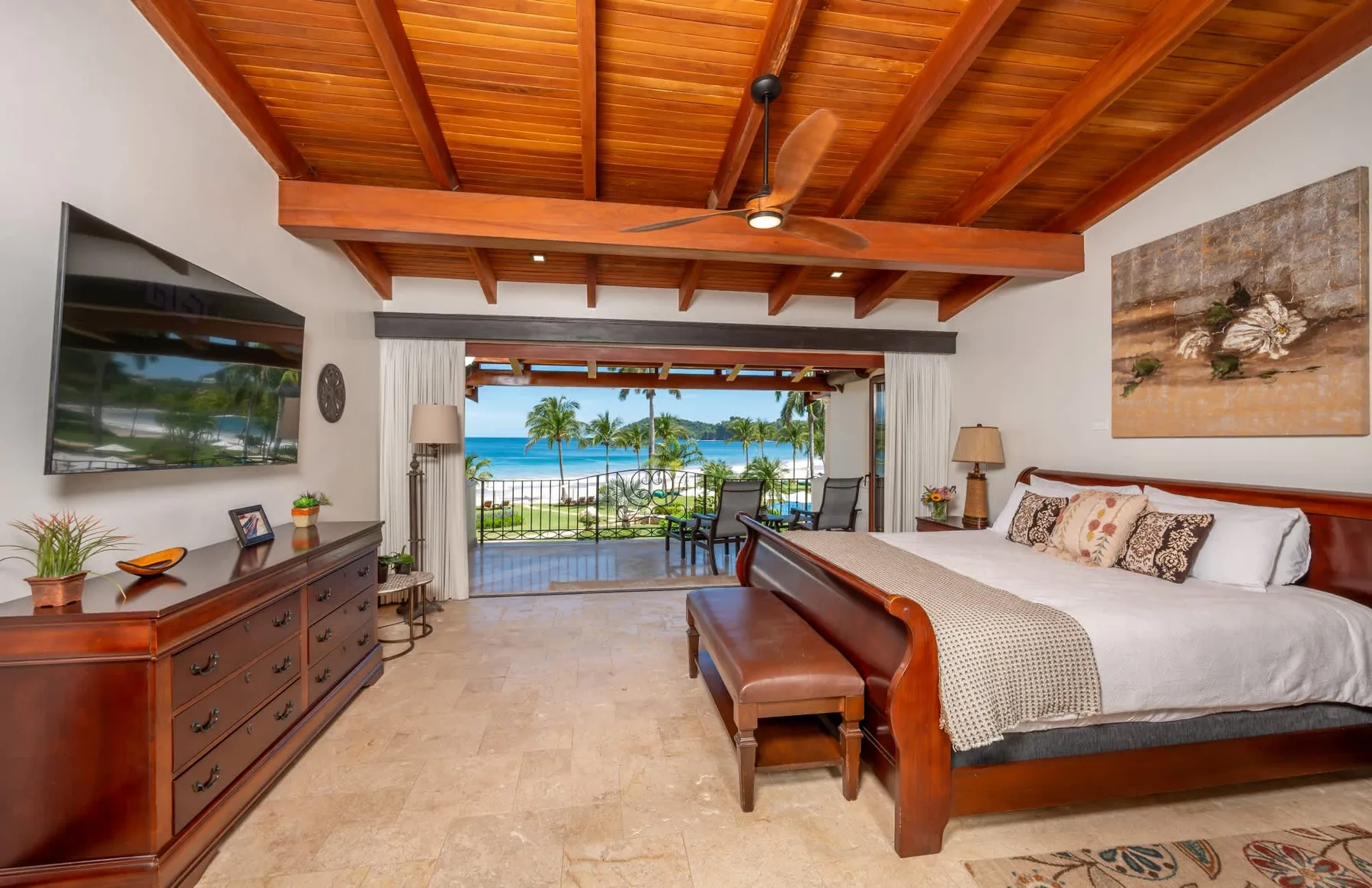 Un dormitorio con una cama grande y un balcón con vista al mar.