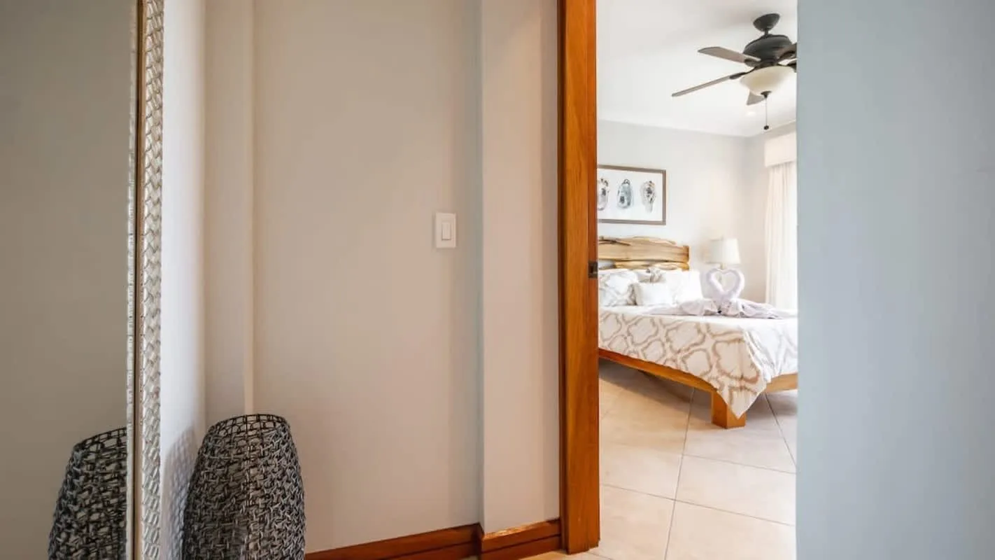 A bedroom with a bed visible through an open doorway.