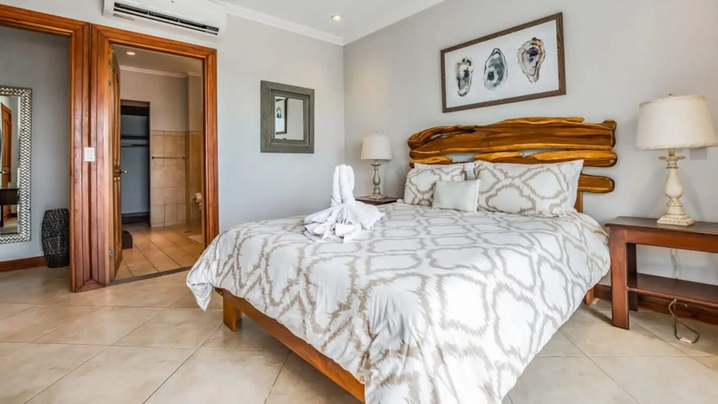 A bedroom with a neatly made bed and matching bedside tables.