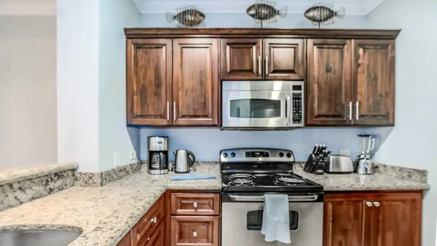 A kitchen with dark wood cabinets, a range, and light countertops.