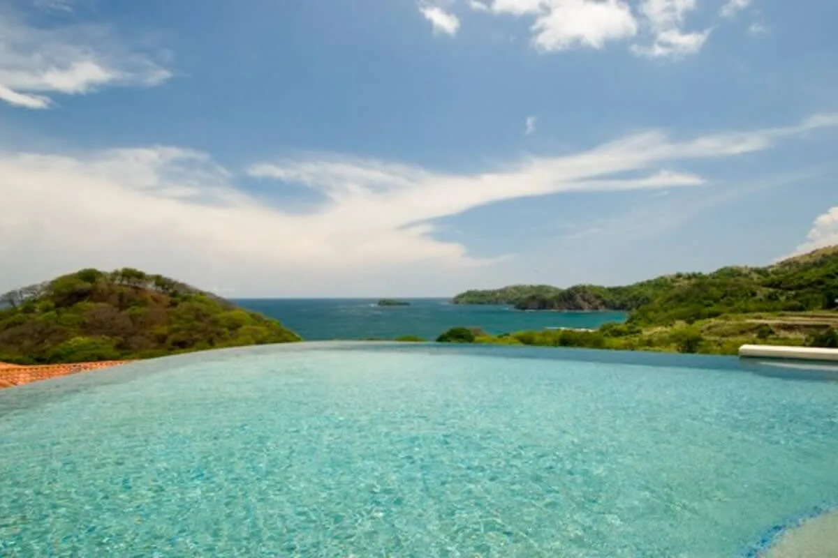 Shared amenity: An infinity pool overlooks the ocean and green hills.