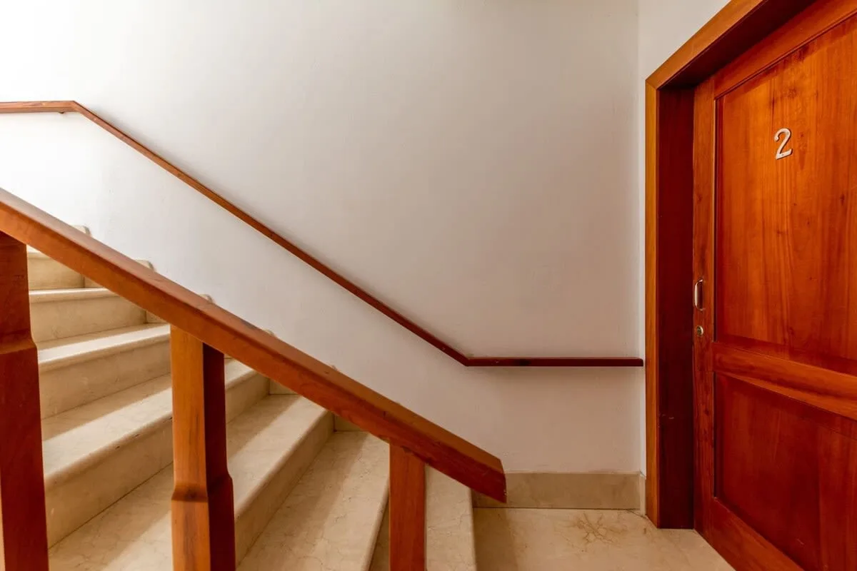 Shared amenity: An indoor staircase beside a wooden door.