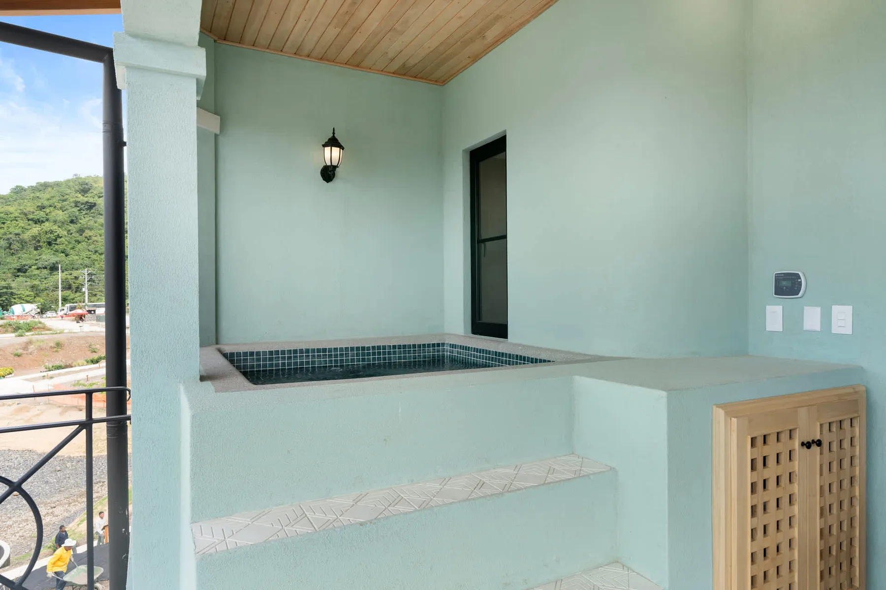 Un espacio exterior cubierto con una pequeña piscina de azulejos y asientos integrados.