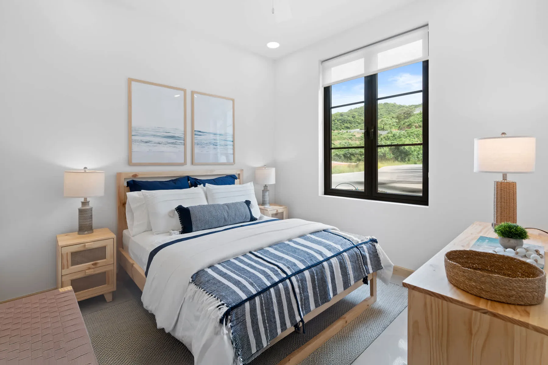 Un dormitorio luminoso con una cama bien tendida y una ventana grande con vistas a zonas verdes.