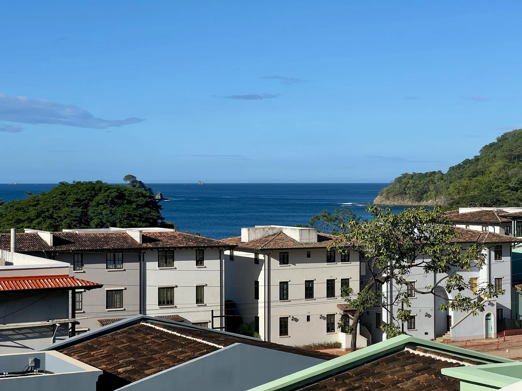 Edificios costeros con vistas al mar bajo un cielo azul despejado.