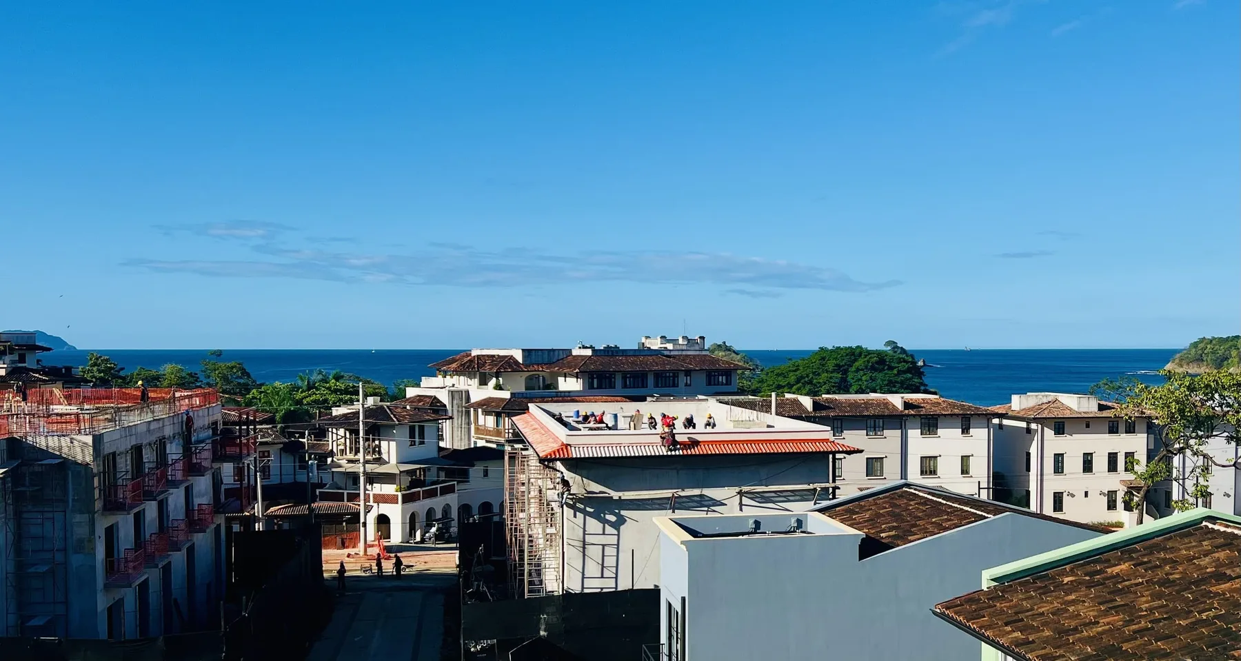 Tejados y edificios se asoman al mar bajo un cielo azul despejado.