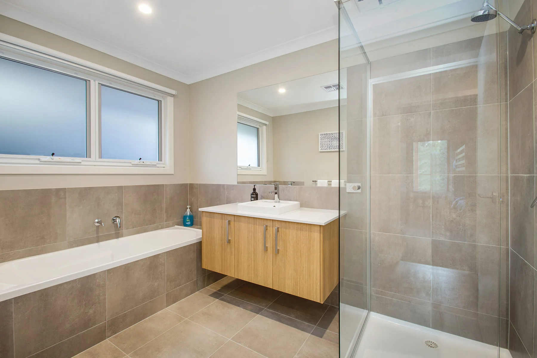 A bathroom with a bathtub, vanity, and glass-enclosed shower.