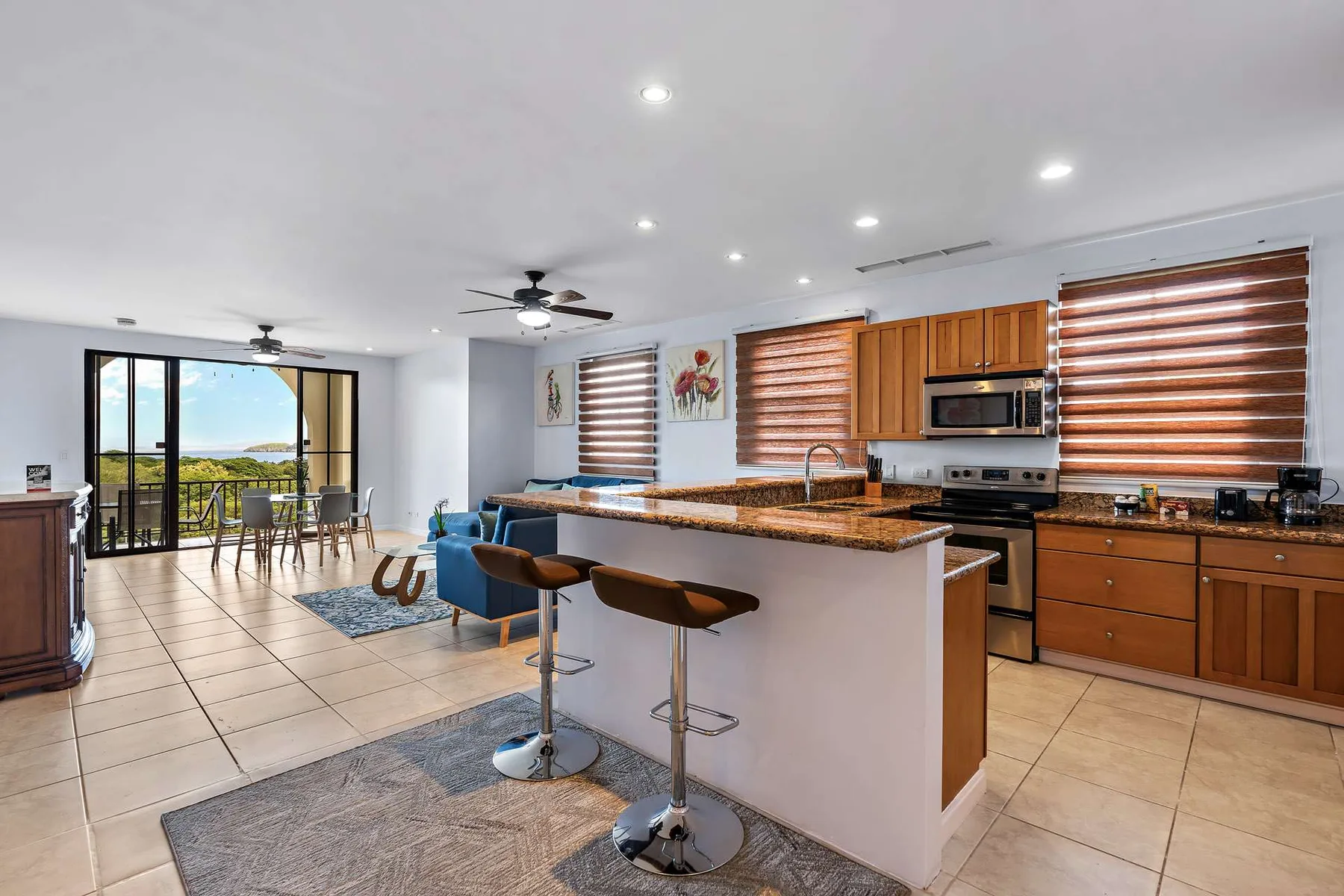 Una cocina y comedor abiertos cuentan con una isla central y puertas corredizas de vidrio.