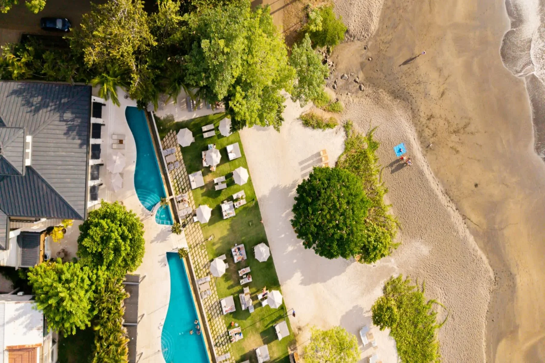 Zona común: Vista aérea de una propiedad junto a la playa, con piscinas y asientos al aire libre.