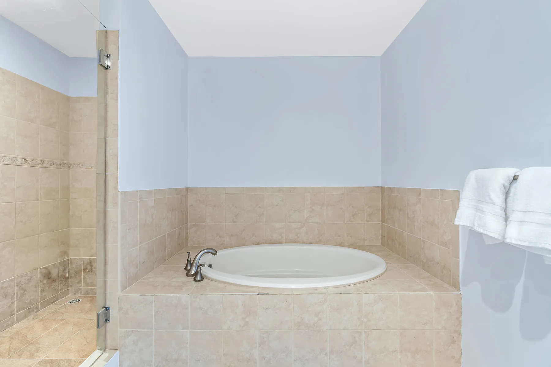 Un baño con una bañera empotrada y paredes de azulejos.