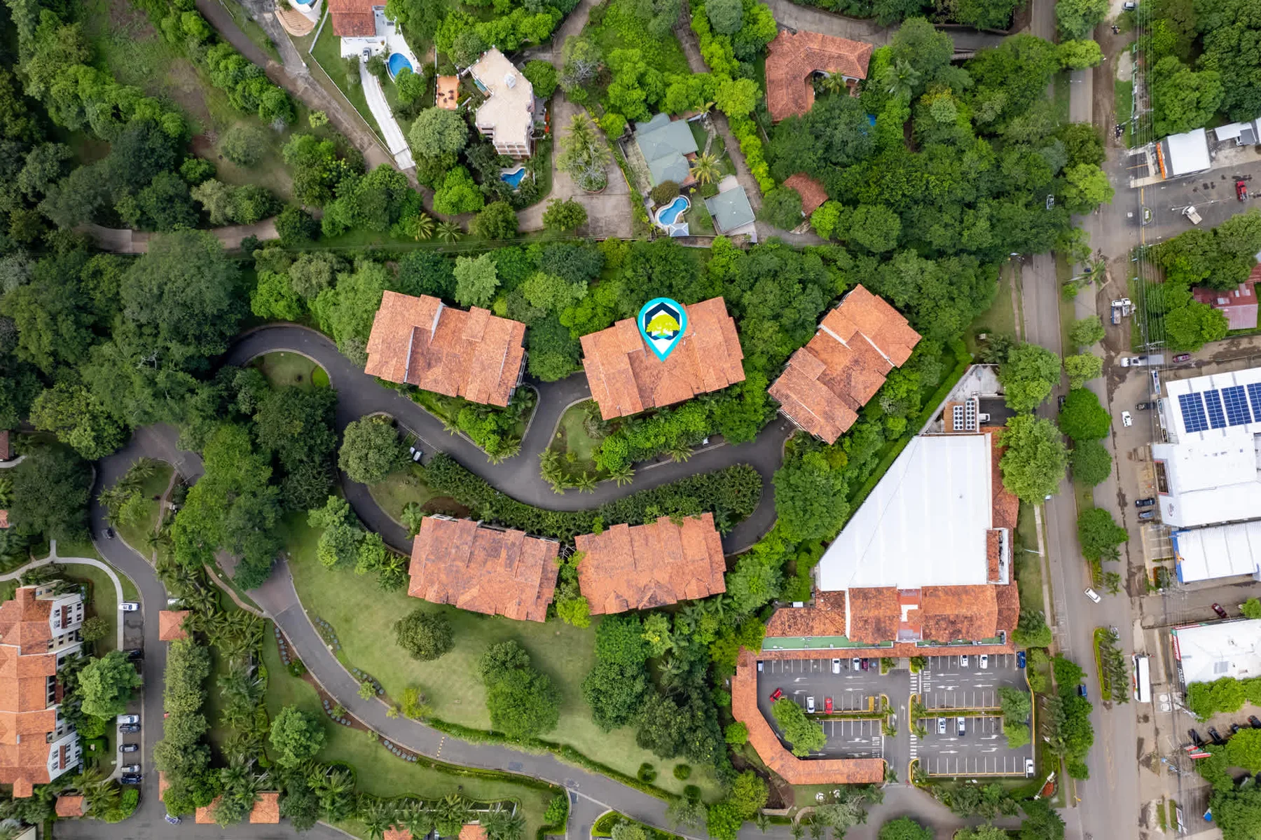 Zona común: Vista aérea de una propiedad arbolada con edificios y caminos sinuosos.