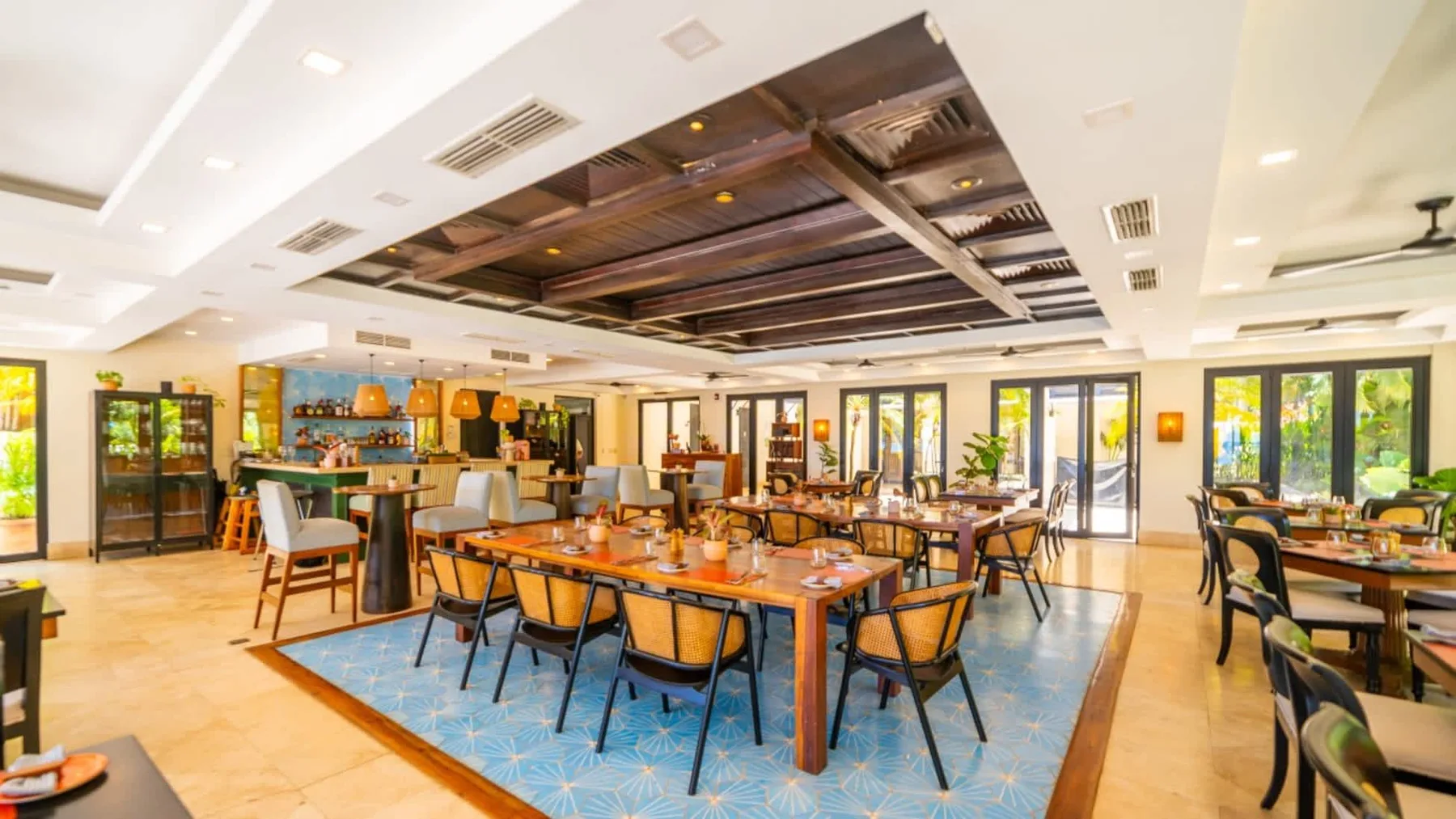 Zona común: Un comedor con mesas largas, sillas y ventanales.