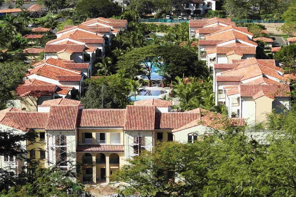 Zona común: Vista aérea de un complejo residencial con tejados de tejas rojas y una piscina central.