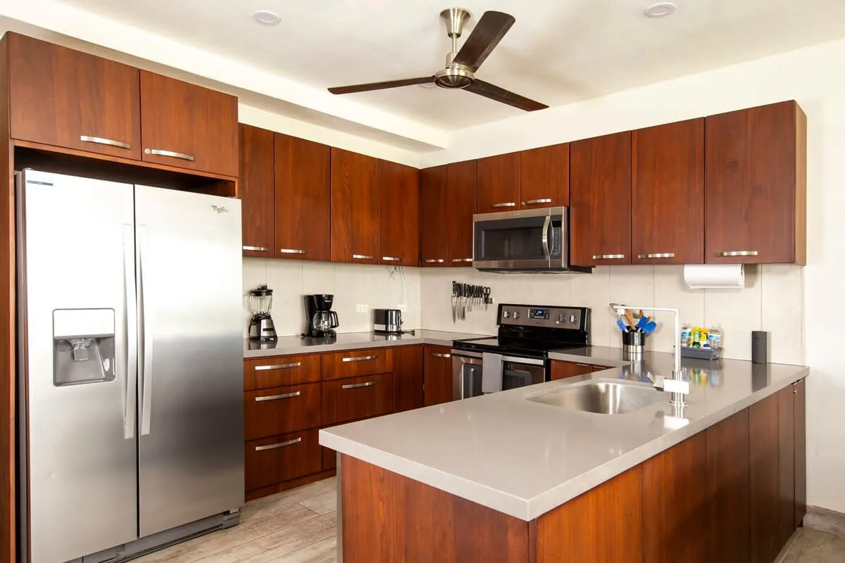 A kitchen with dark wood cabinets, stainless steel appliances, and a central island.