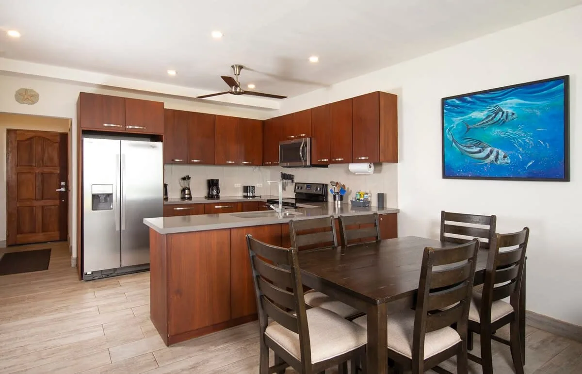 An open kitchen and dining area with wooden cabinets and a dining table.