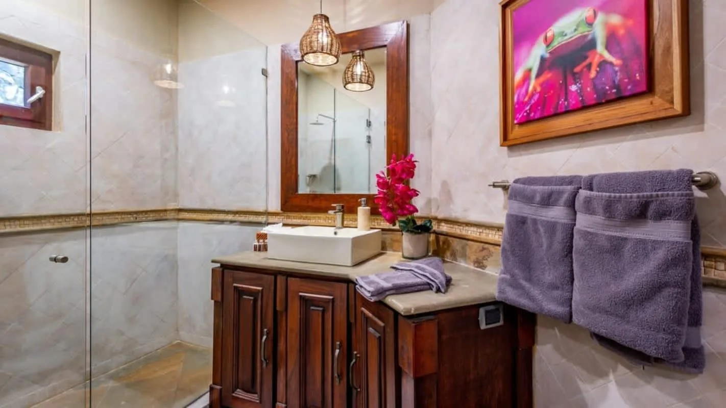 A bathroom vanity with a sink, mirror, and purple towels.