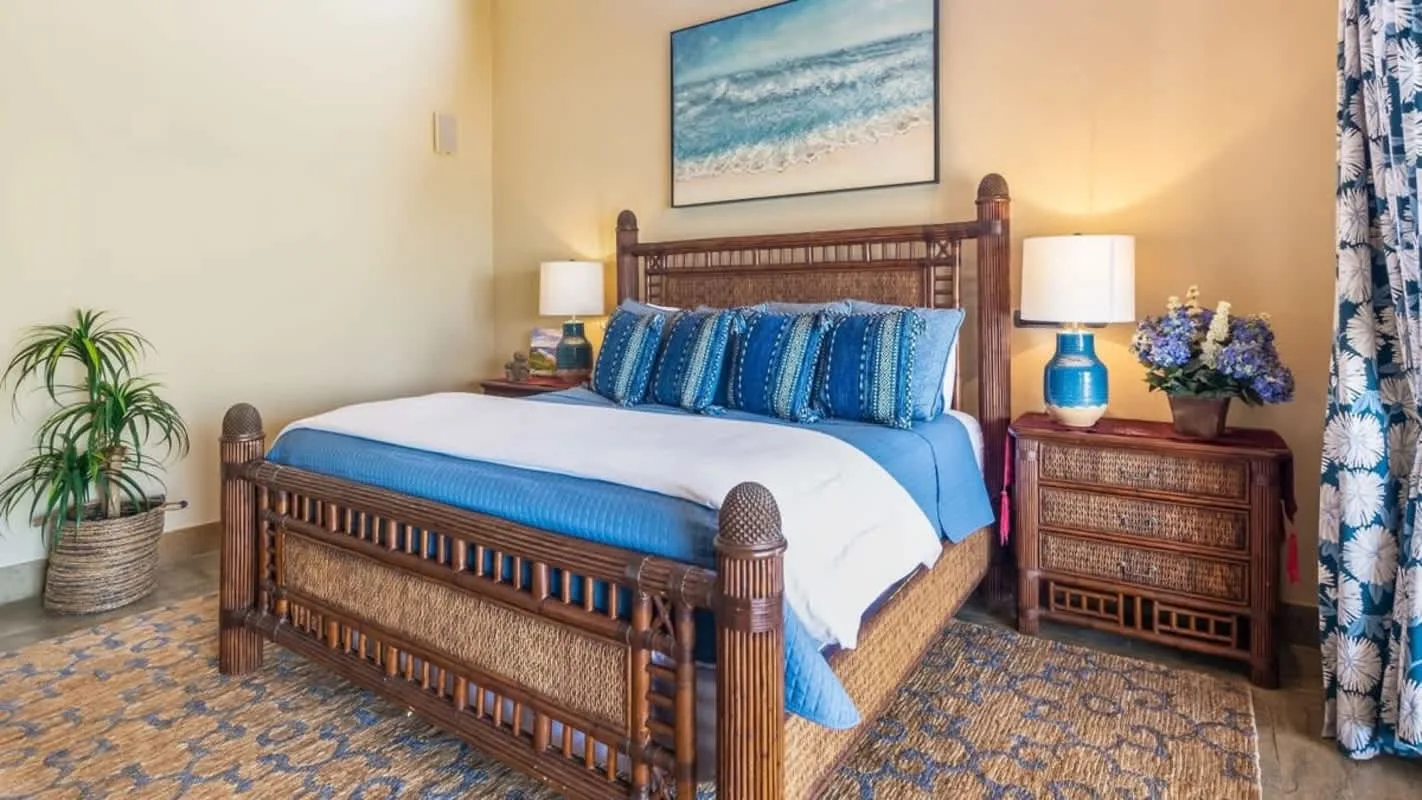 A bedroom with a wooden bed dressed in blue and white bedding.