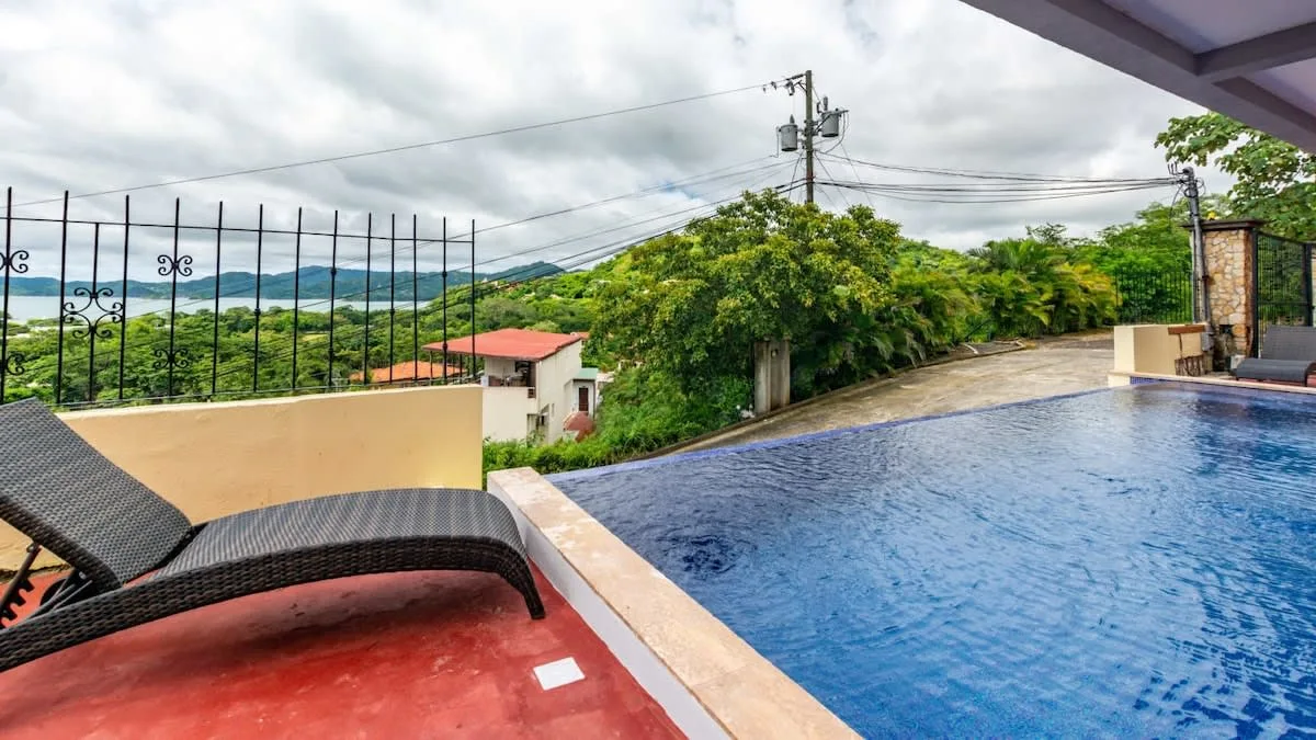 Zona común: Una piscina al aire libre junto a asientos de descanso da a un paisaje verde.