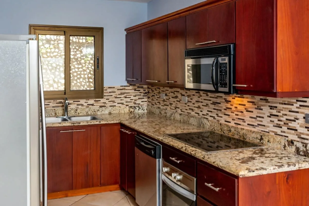 A kitchen with wooden cabinets, a countertop, and built-in appliances.
