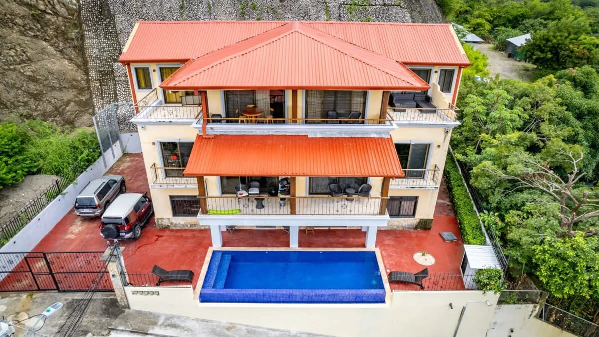 Zona común: Un edificio con balcones da a una piscina azul.