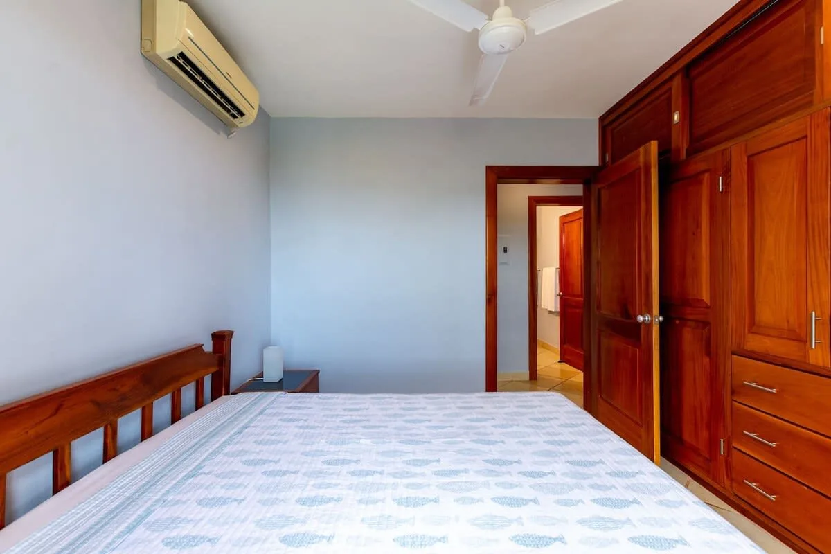 Un dormitorio con una cama, armarios de madera y una puerta.