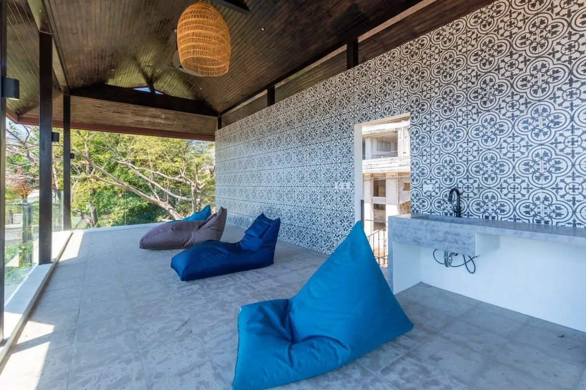 A covered open-air lounge with blue beanbag seating and patterned walls.
