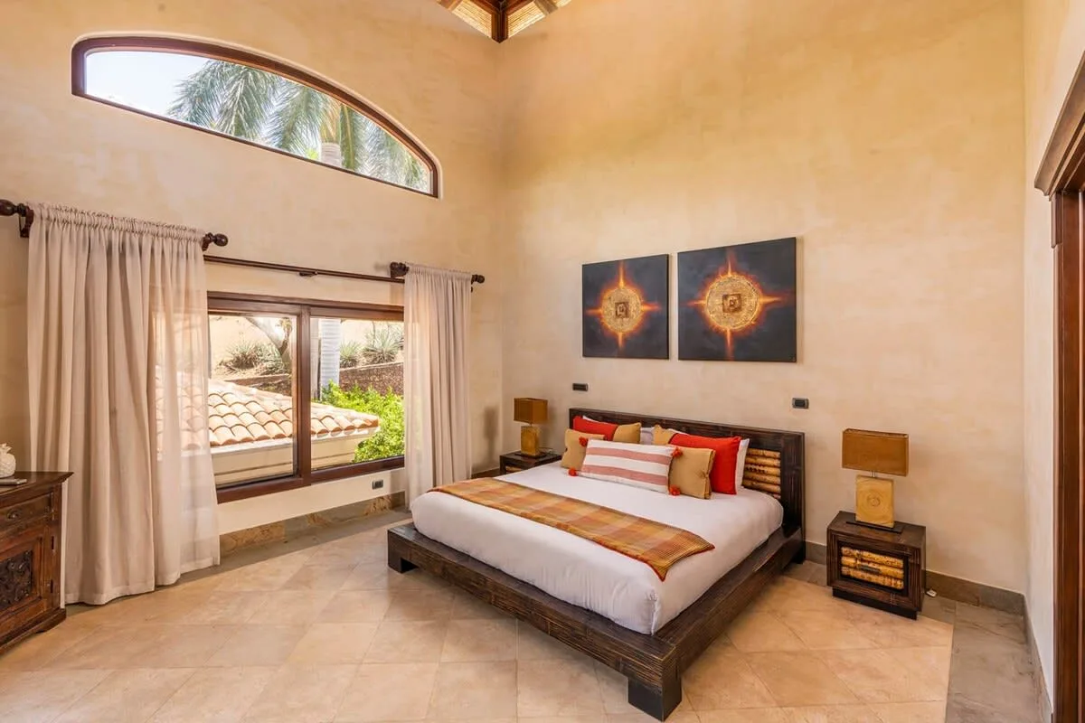 A bedroom with a large bed beneath two decorative wall panels.