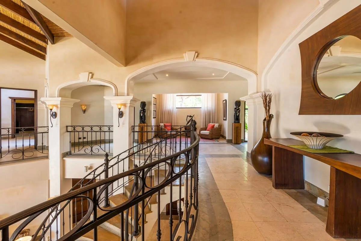 A spacious interior hallway with a curved railing and seating visible in the background.