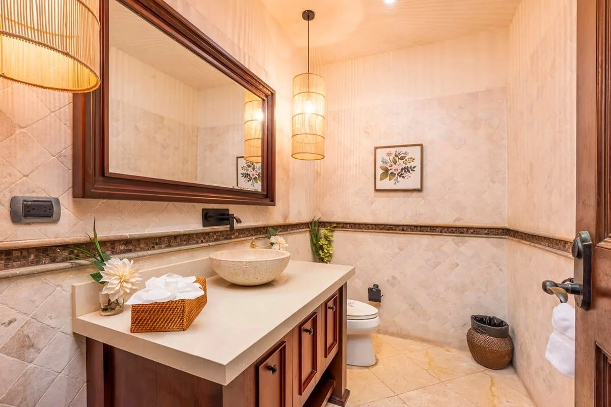 A bathroom with a vanity, vessel sink, and large wall mirror.