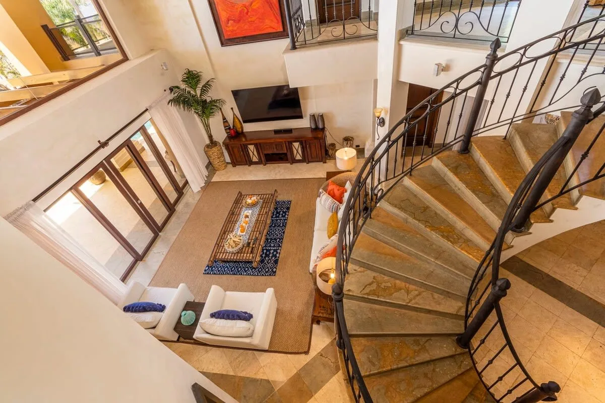 A two-story living room with a curved staircase and seating area.