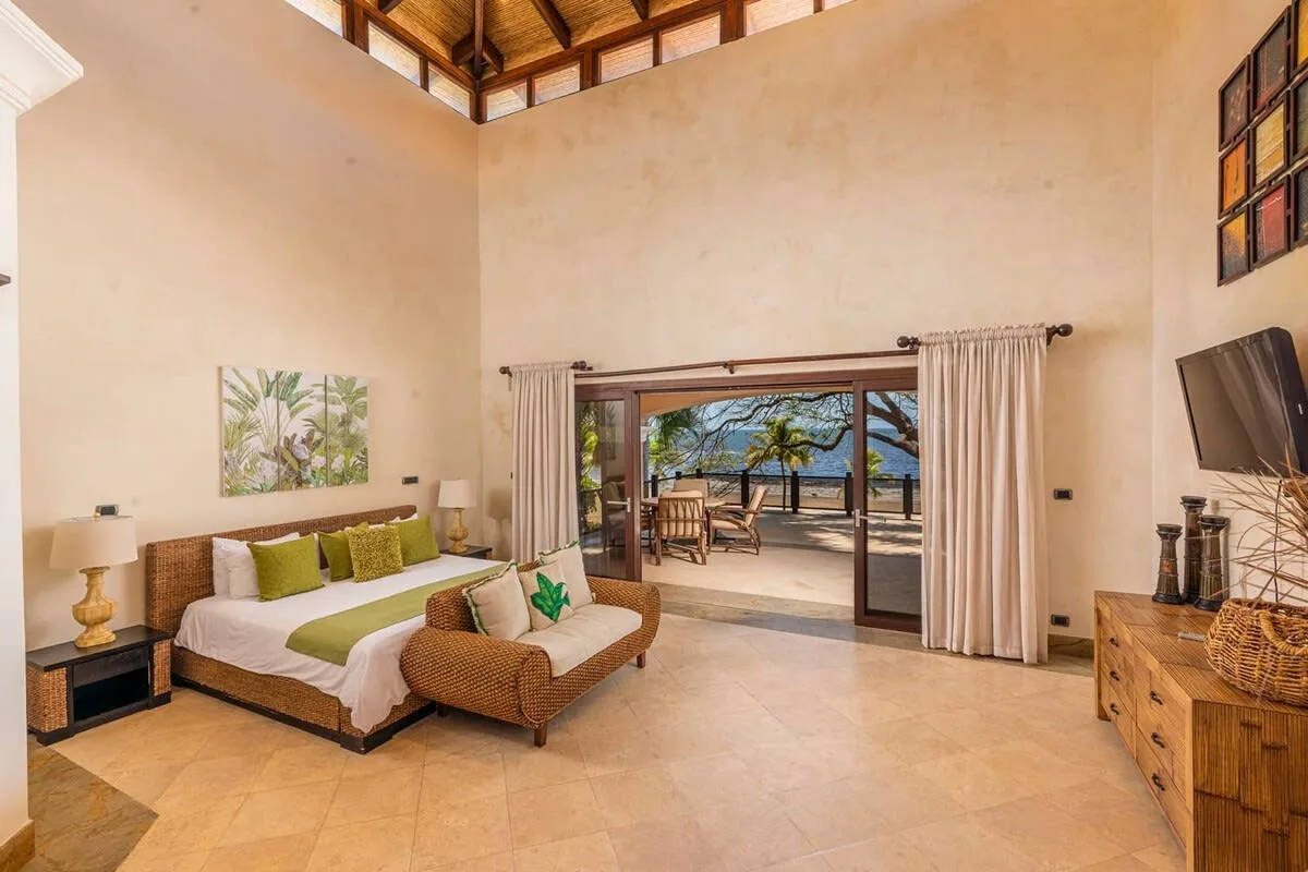A spacious bedroom opens onto a patio, with a bed and seating area.